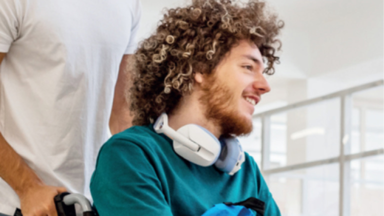 Un étudiant en chaise roulante poussé par un autre étudiant